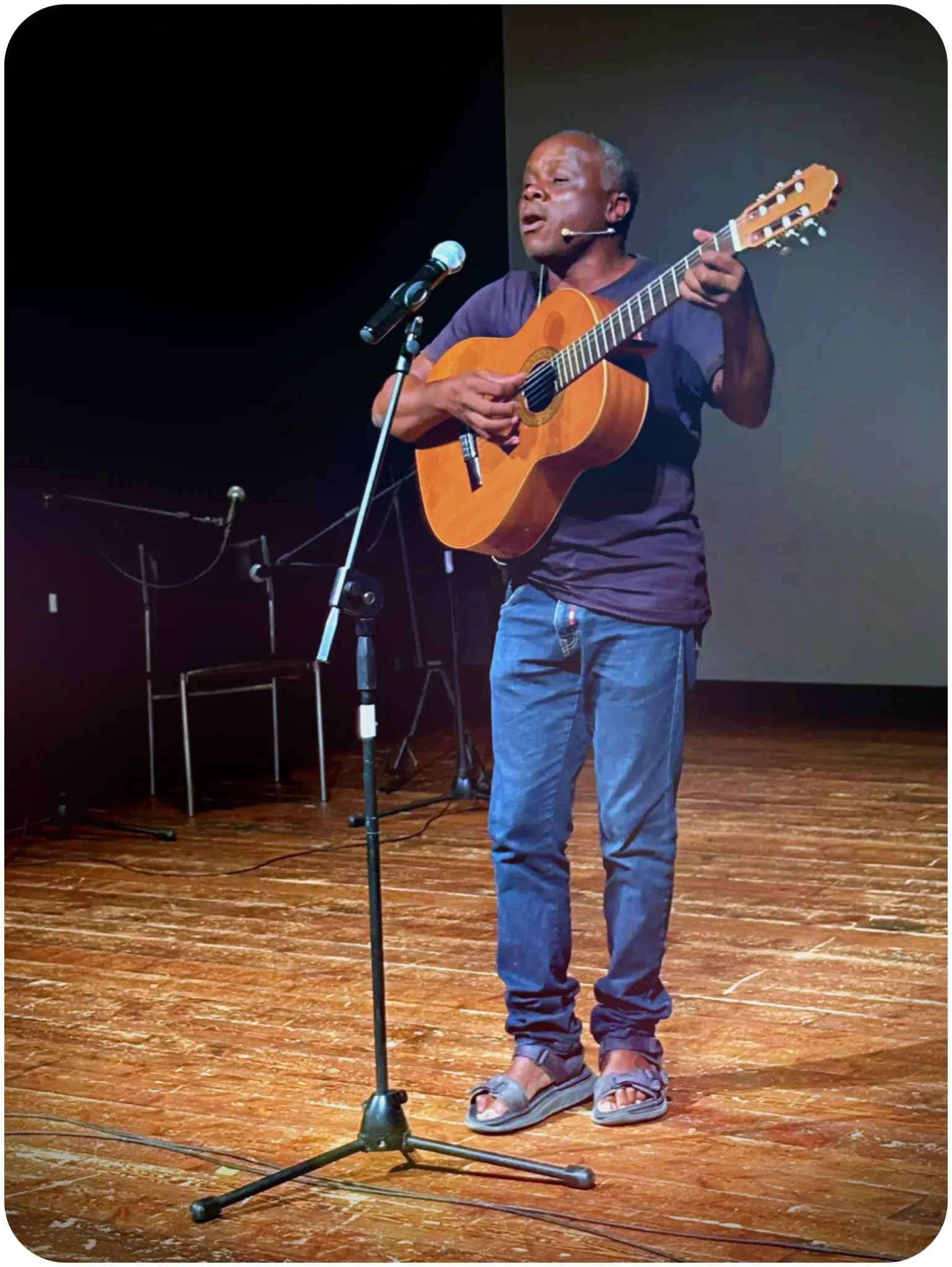 Henri Olama canta e suona la chitarra sul palco del Teatro di Anghiari